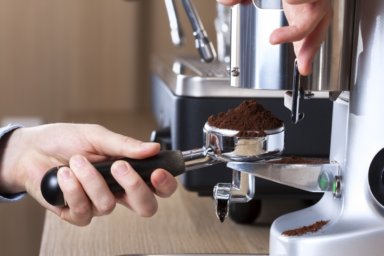 Elektrische Kaffeemühle mahlt den Kaffee in einen Siebträger